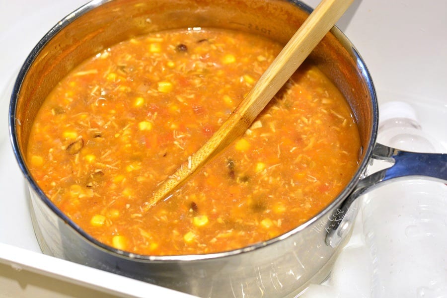 Chicken Tortilla Soup in a pan with a wooden spoon in it