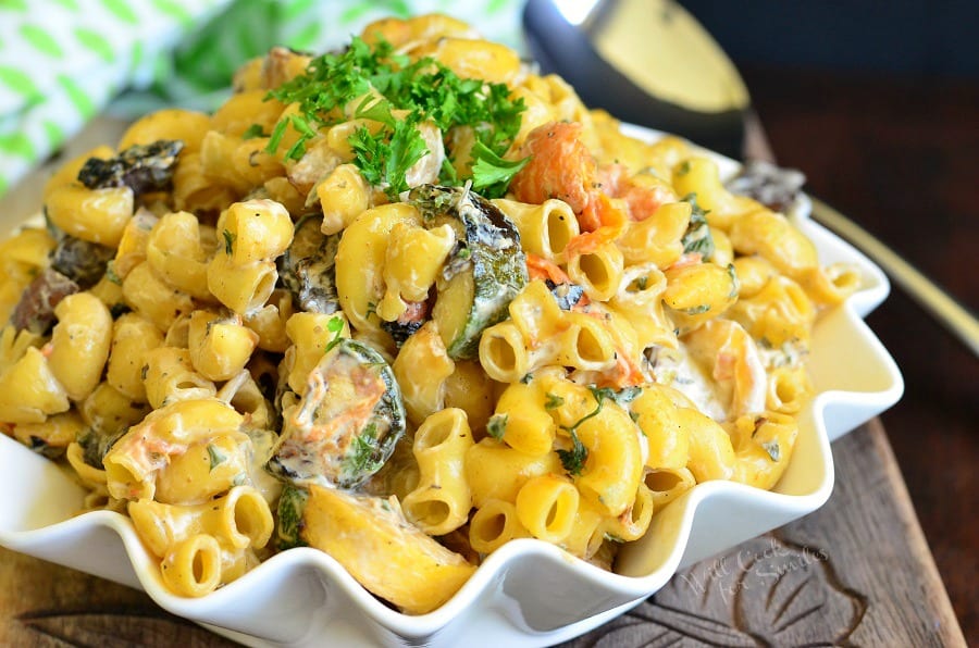 Grilled Vegetable Pasta Salad in a bowl on a cutting board with a spoon 