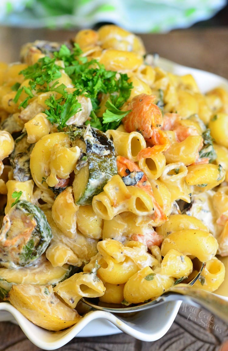 Grilled Vegetable Pasta Salad in a bowl with a spoon on a wood table 