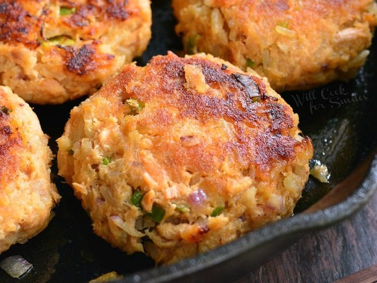 cooked salmon and rice patties in a cast iron skillet