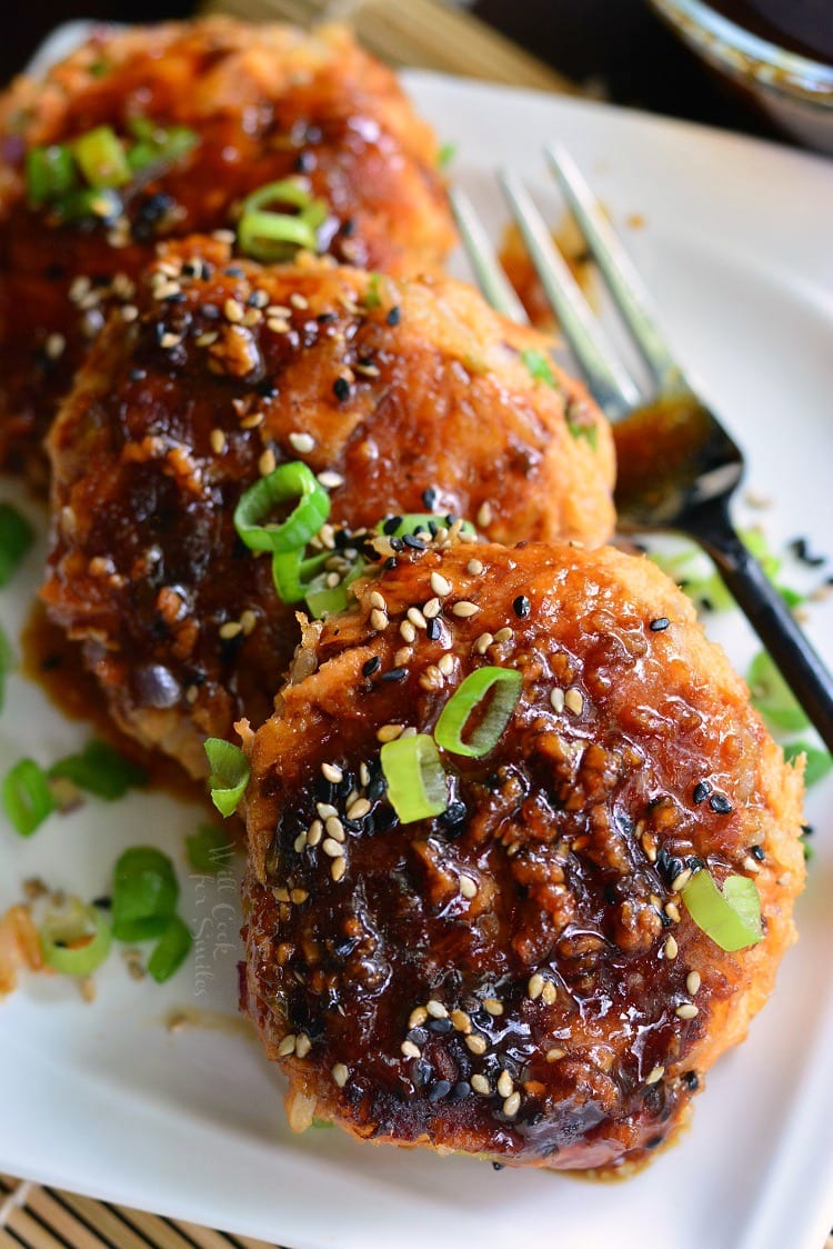 Teriyaki Rice and Salmon Patties cooked on the plate topped with sauce and sliced green onions