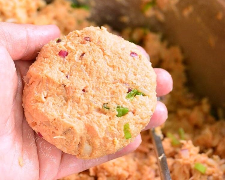 holding uncooked, shaped salmon patty