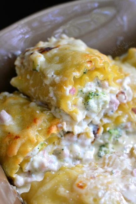 closeup of stacked lasagna roll ups in the baking dish.