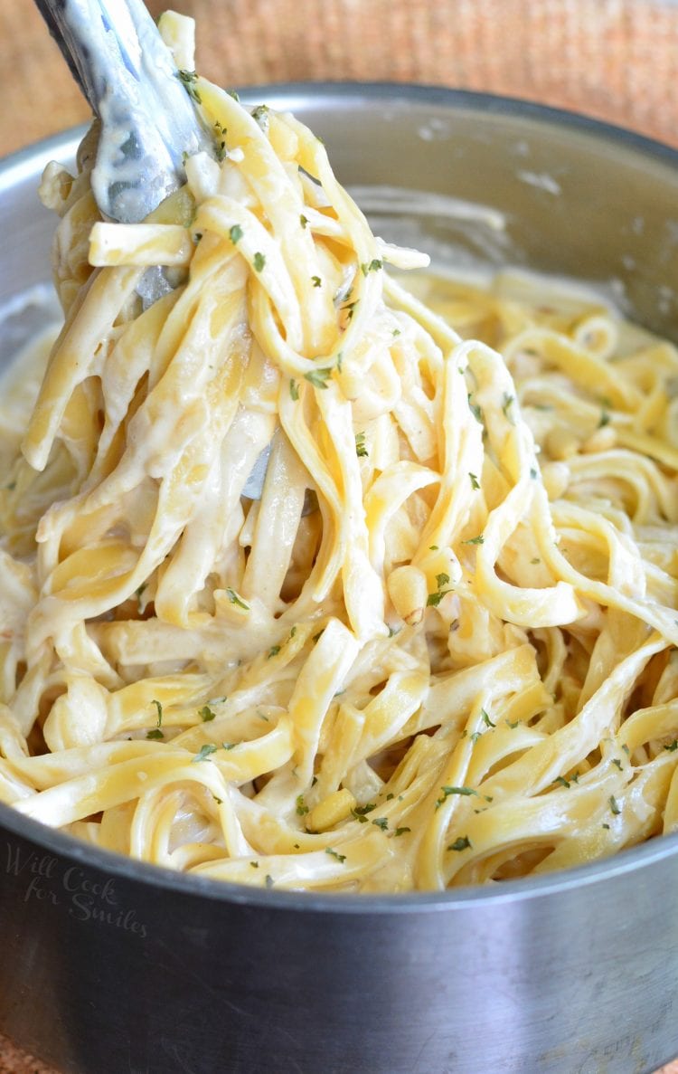 Roasted Garlic Asiago Fettuccine in a metal bowl with metal tongs 