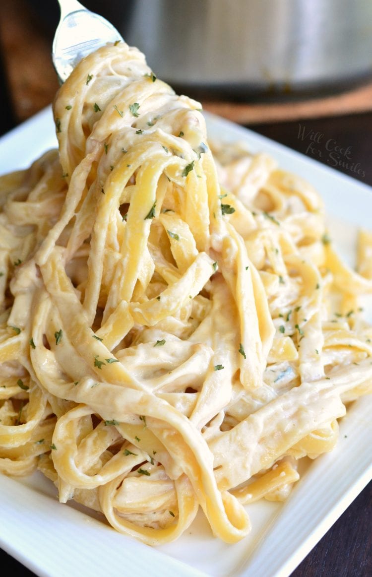 Roasted Garlic Asiago Fettuccine on a plate with a fork lifting some out 