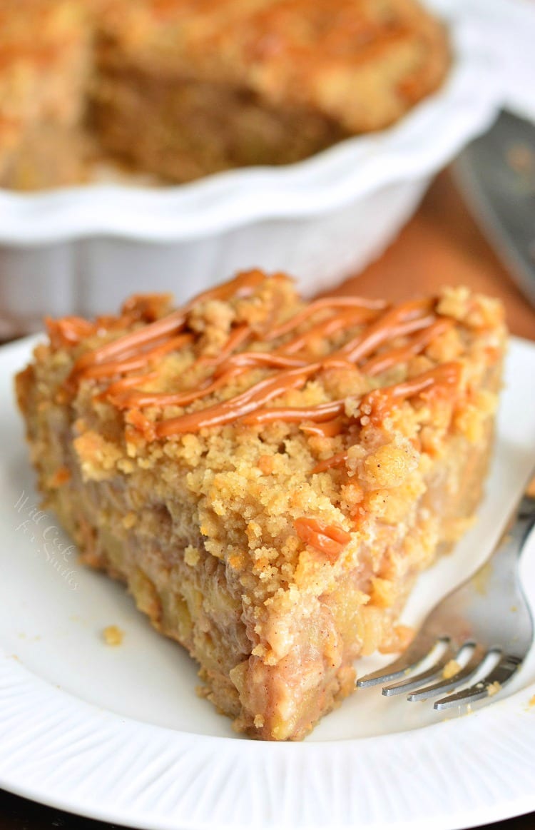 Caramel Apple Cookie Crust Pie on a white plate with a fork the rest of the pie in the background 