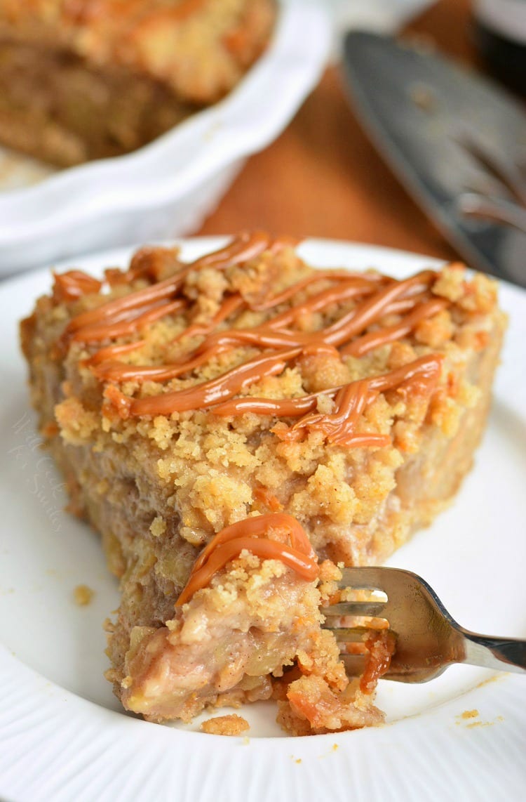 a piece of caramel apple pie cut off the slice of pie with a fork.