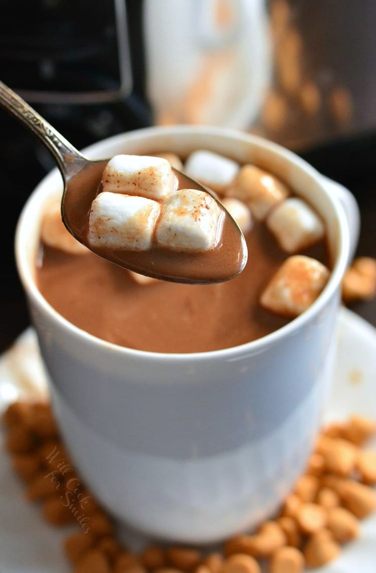 spooning mini marshmallows and some hot chocolate from the mug