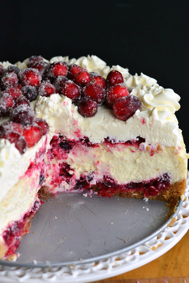 Christmas Cheesecake with slices taken out on a cake stand 