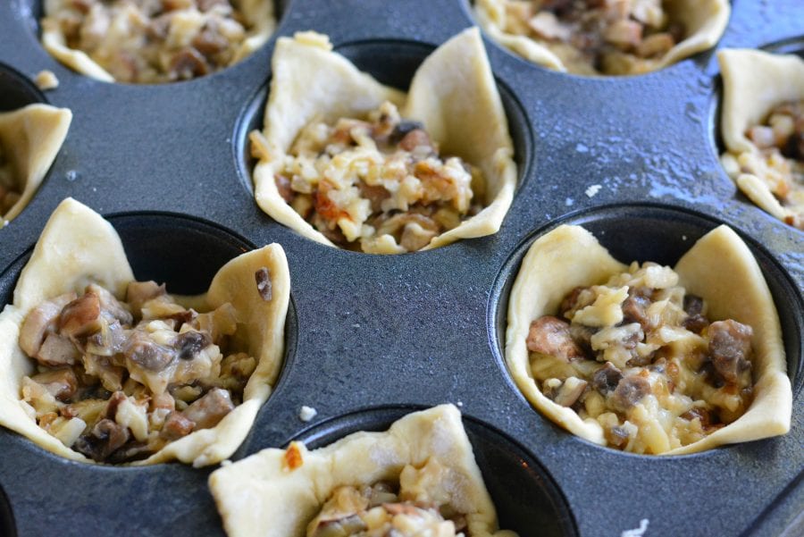  bouchées feuilletées au fromage aux champignons non cuites dans un moule à muffins 