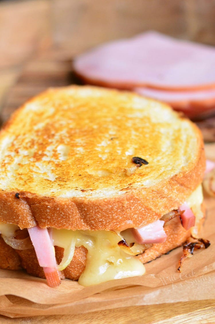 Ham and Brie Grilled Cheese Sandwich on parchment paper on a cutting board 