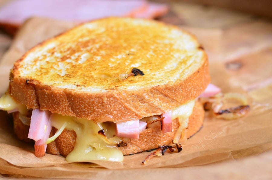 Ham and Brie Grilled Cheese Sandwich on parchment paper on a cutting board 