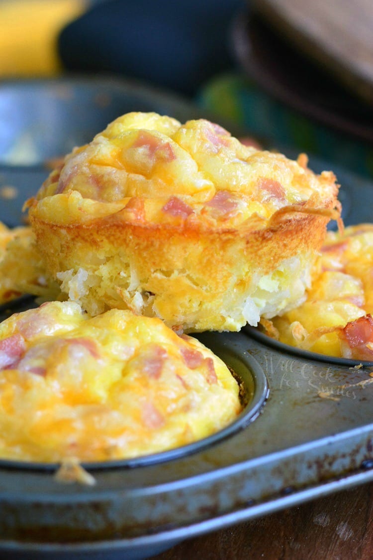 Ham Egg and Cheese Hash Brown Breakfast Muffins stacked on a muffin pan 