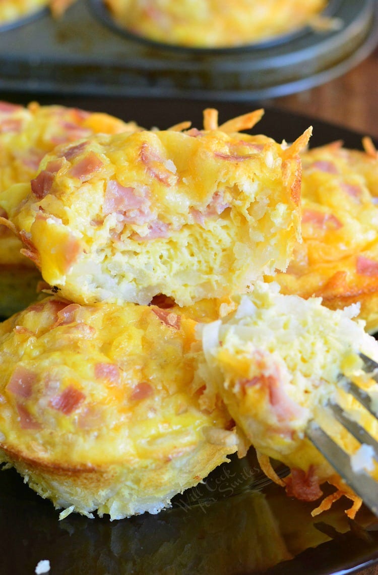 Ham Egg and Cheese Hash Brown Breakfast Muffins stacked on a muffin pan with a fork 