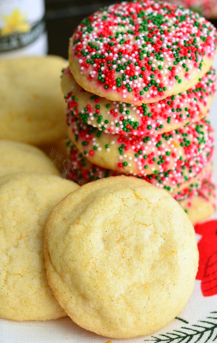 Sugar Cookies with Orange and Vanilla stacked on a plate some with sprinkles 