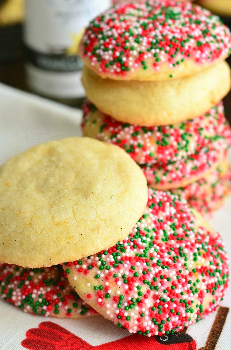 Sugar Cookies with Orange and Vanilla stacked on a plate some with sprinkles 