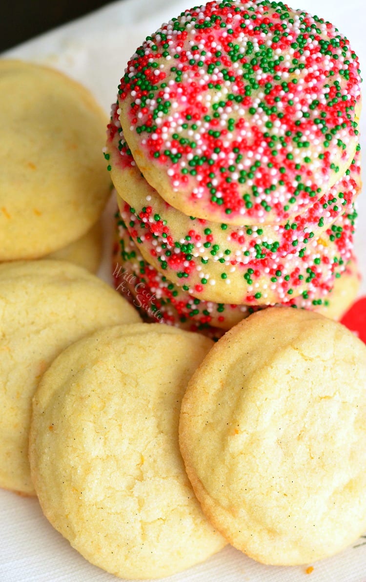 Sugar Cookies with Orange and Vanilla stacked on a plate some with sprinkles 