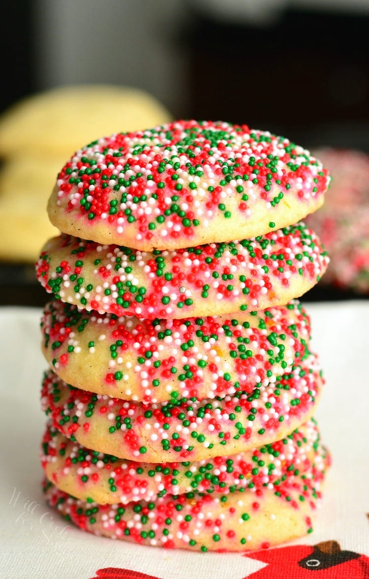 Sugar Cookies with Orange and Vanilla stacked on a plate with sprinkles 