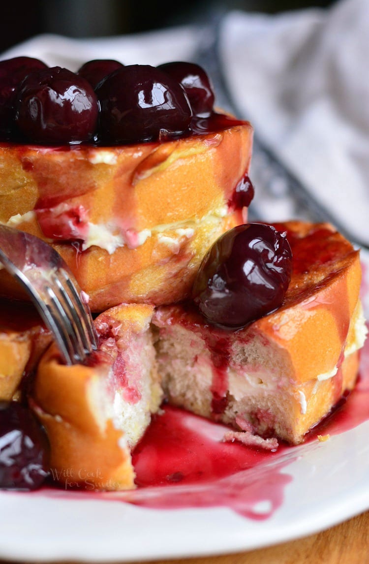 Cherry Cheesecake Stuffed French Toast stacked on a plate on a plate with a fork 