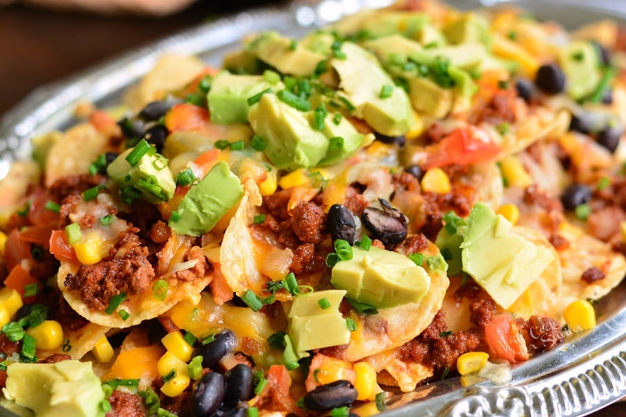 vertical Chorizo Nachos on a silver plater. 