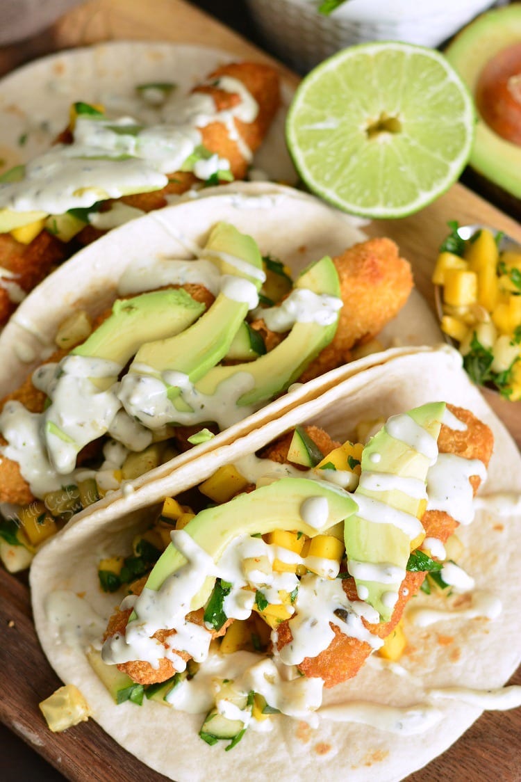 Crispy Fish Tacos with Cucumber Mango Relish on a cutting board 