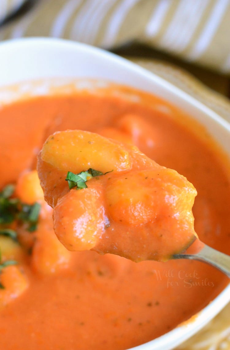 Homemade Tomato Soup with Gnocchi in a bowl with some scooped on a spoon 