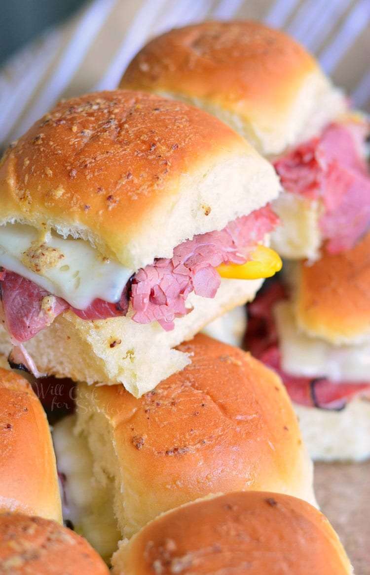 Hot Pastrami Sliders stacked up in a baking dish 