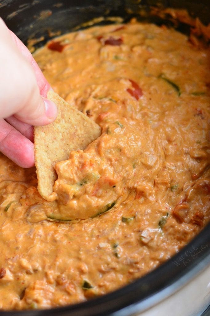 dipping a regular corn tortilla chip into the enchilada dip.