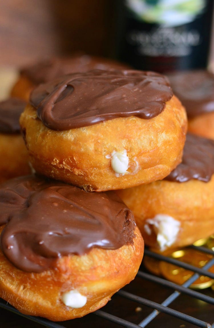 Bailey's Cheesecake Doughnuts stacked on a cooling rack 