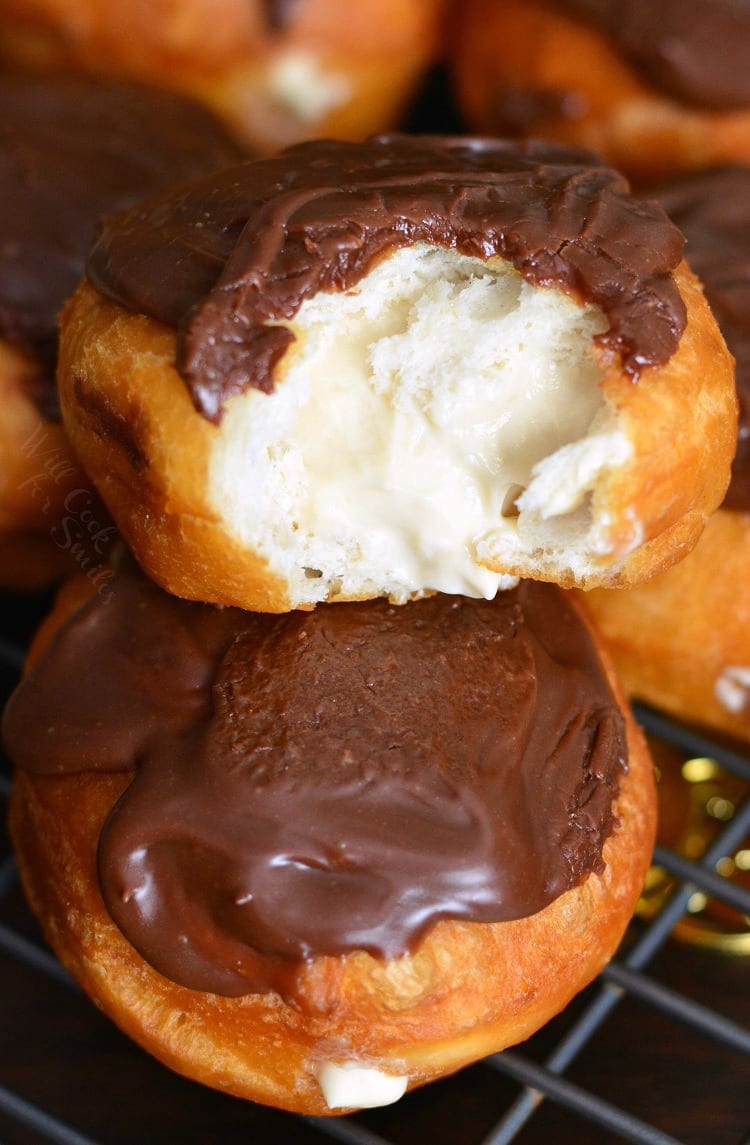 Bailey's Cheesecake Doughnuts on a cooling rack with a bite taken out of one 