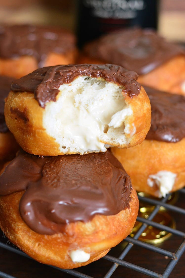 Bailey's Cheesecake Doughnuts on a cooling rack with a bite out of one of them 