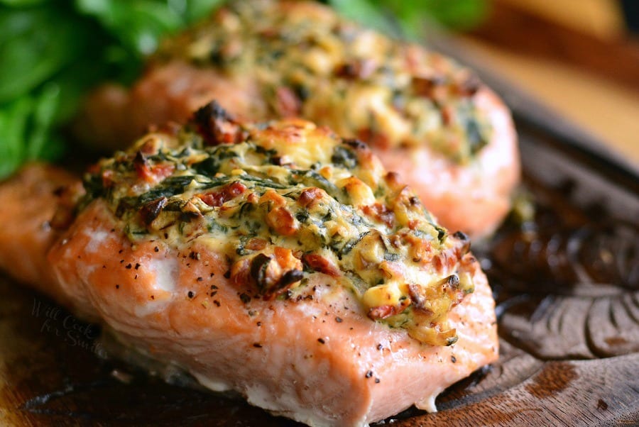 Creamy Spinach and Sun Dried Tomato Stuffed Salmon on a cutting board 