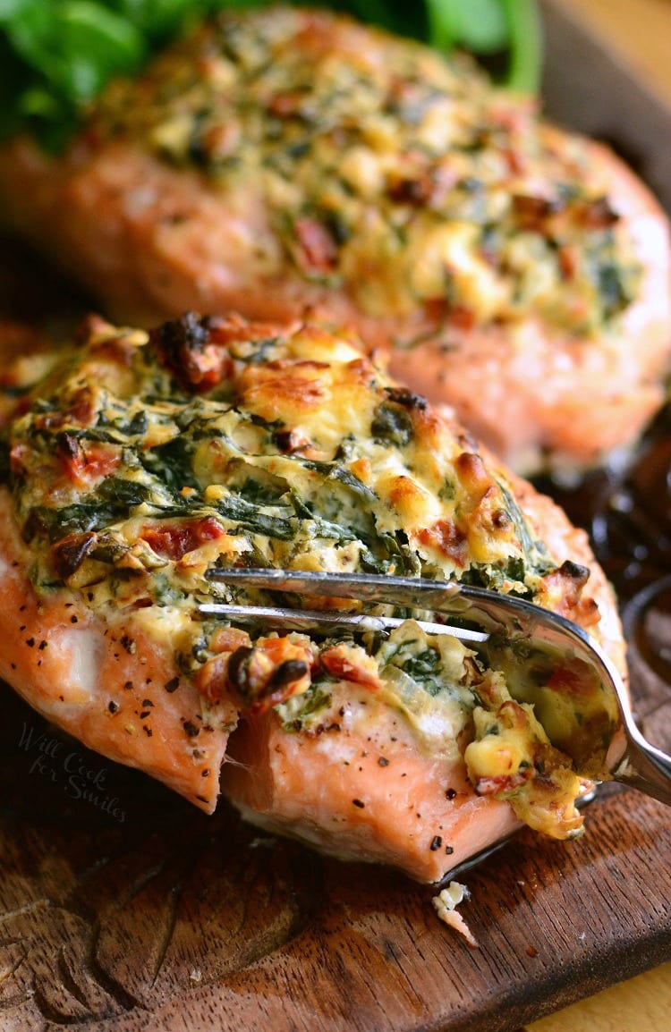 Creamy Spinach and Sun Dried Tomato Stuffed Salmon on a cutting board 