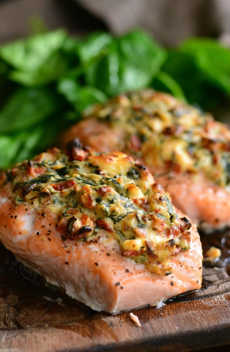 Creamy Spinach and Sun Dried Tomato Stuffed Salmon on a wood cutting board 