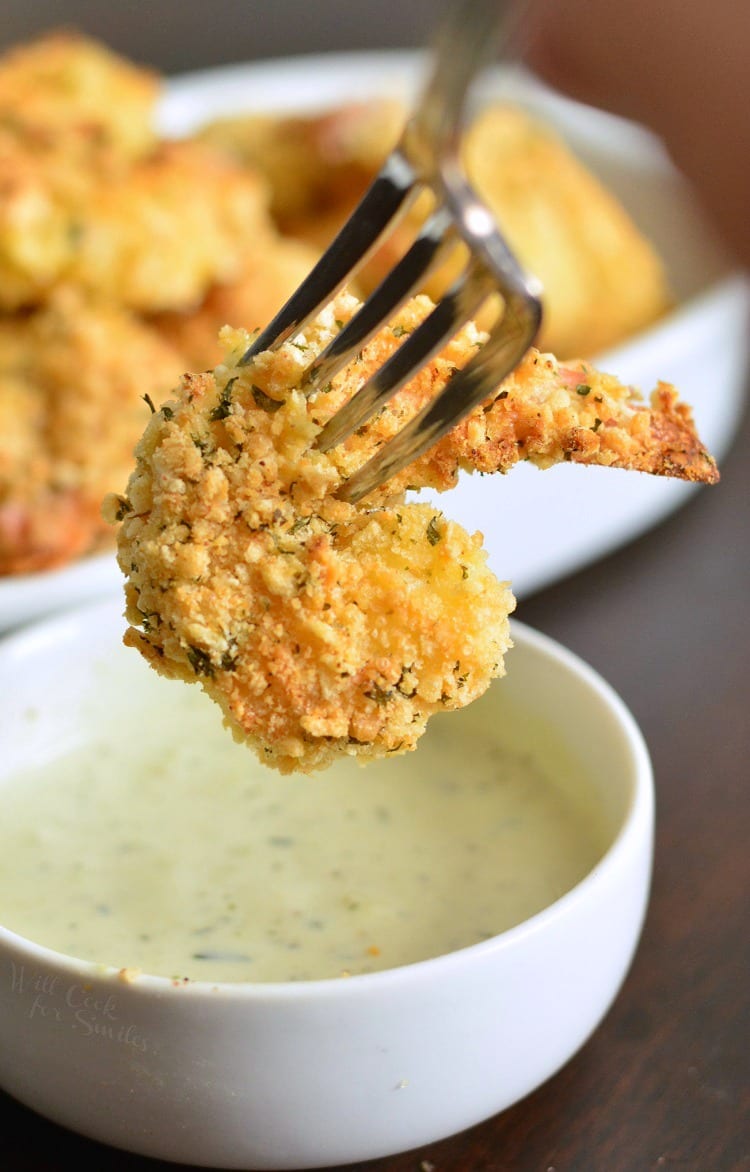 dipping Oven Baked Crispy Parmesan Garlic Shrimp into a bowl of ranch with a fork 