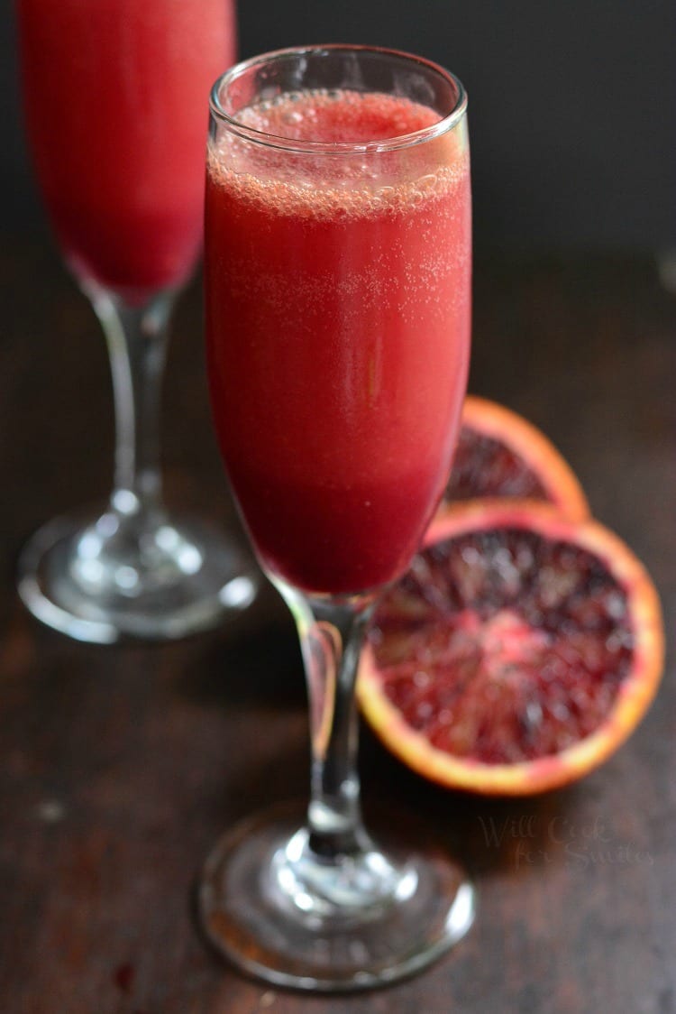 Blood Orange Mimosa in a glass with sliced blood orange next to the glass