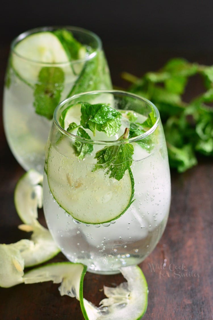 close up of Cucumber Mint Gin Cocktails garnished with thin slice of cucumber and muddled mint