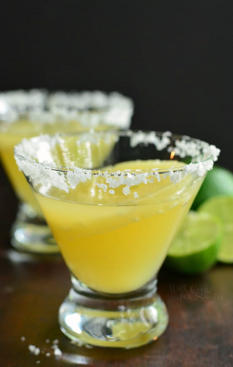 close up of margarita in a glass with pineapple ring and salted rim