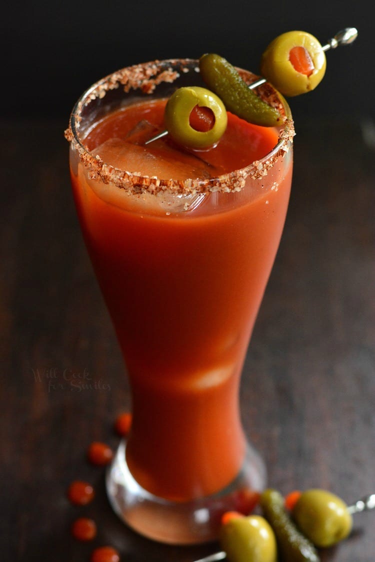 Bloody Mary cocktail in a glass with olives and pickle as a garnish