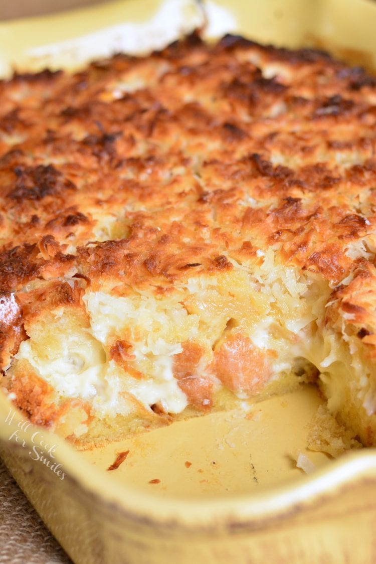 Pouding au pain au fromage à la noix de coco dans un plat allant au four avec un morceau manquant