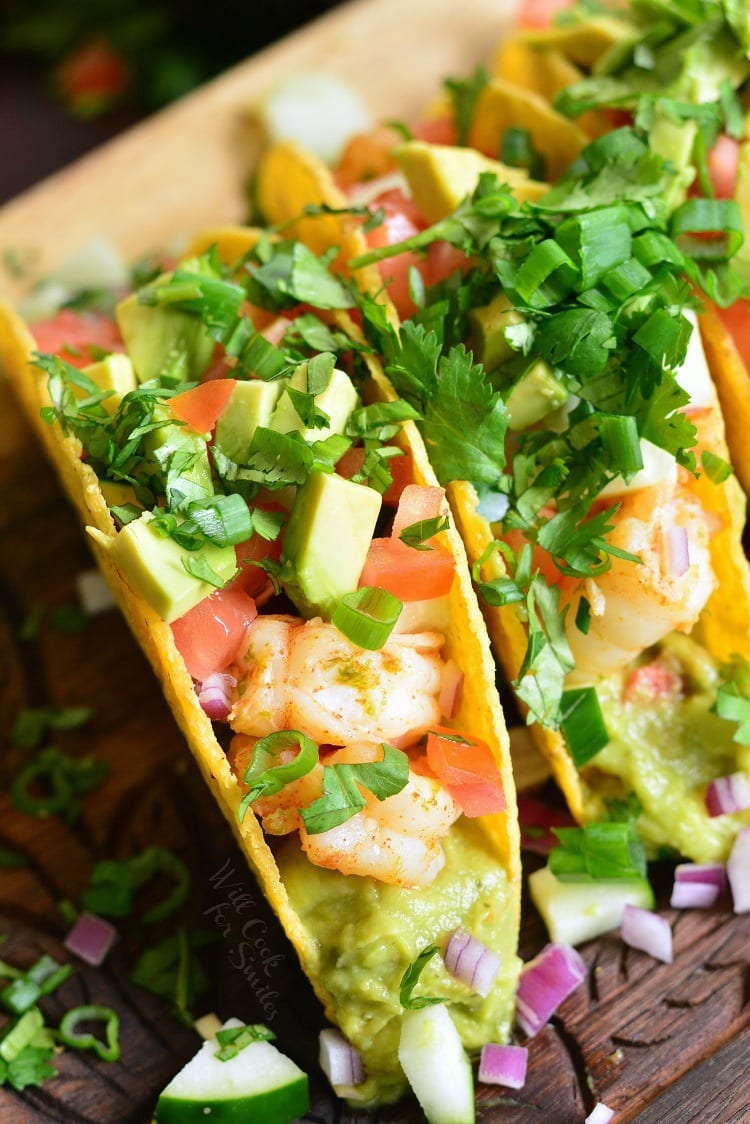 top view of shrimp tacos with guacamole avocado and vegetables