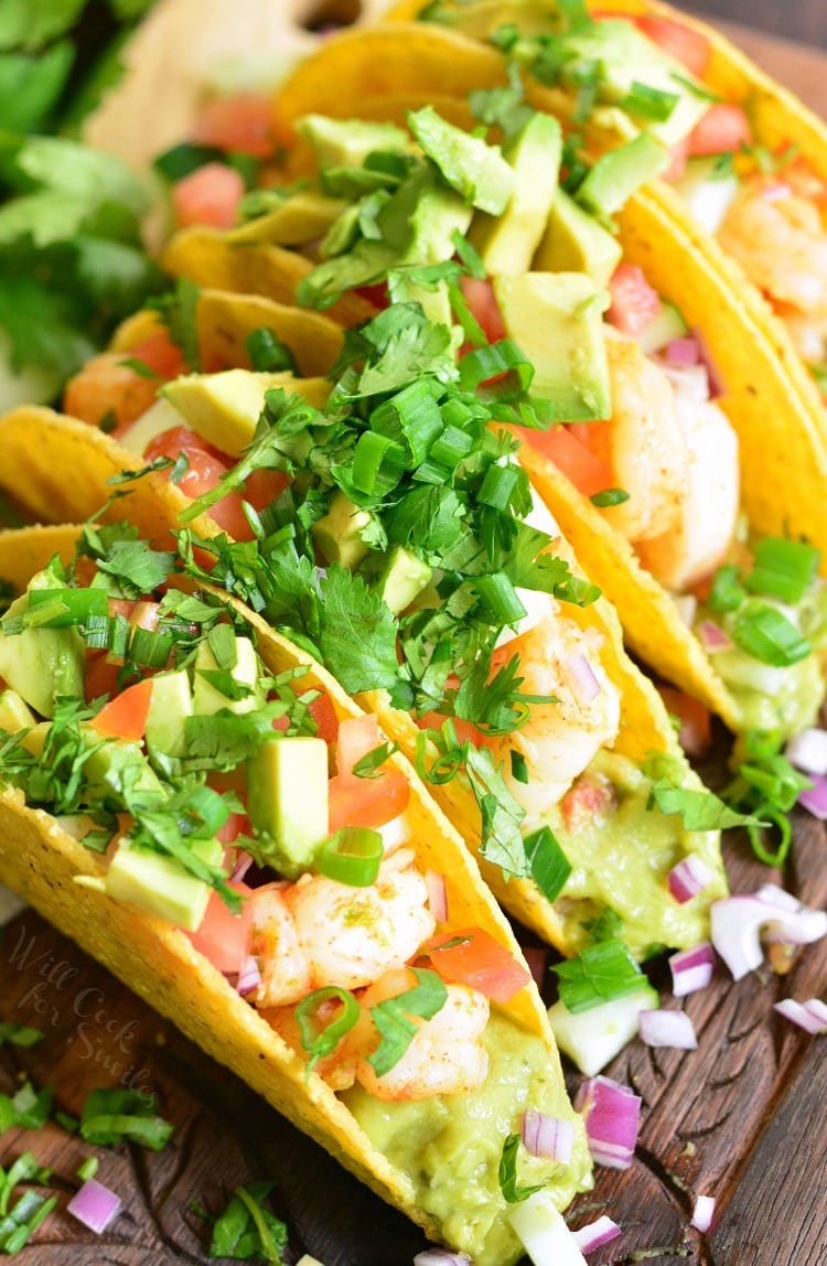 3 hard taco shells filled with shrimp, guacamole and avocados.