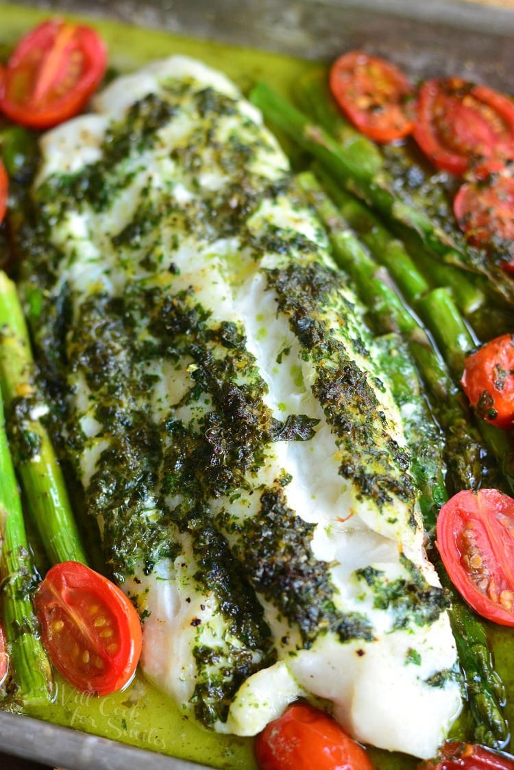 Lemon Herb Butter Cod with Asparagus and Tomatoes in a baking dish 