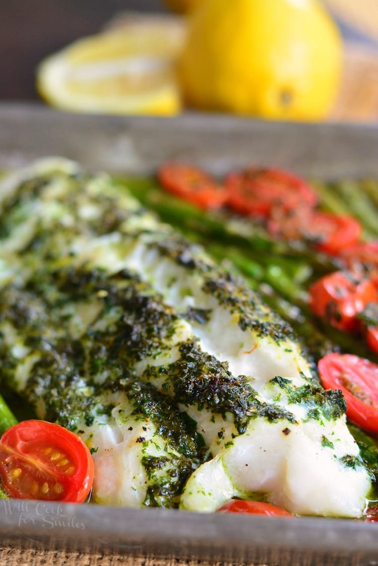 Lemon Herb Butter Cod with Asparagus and Tomatoes in a baking dish 