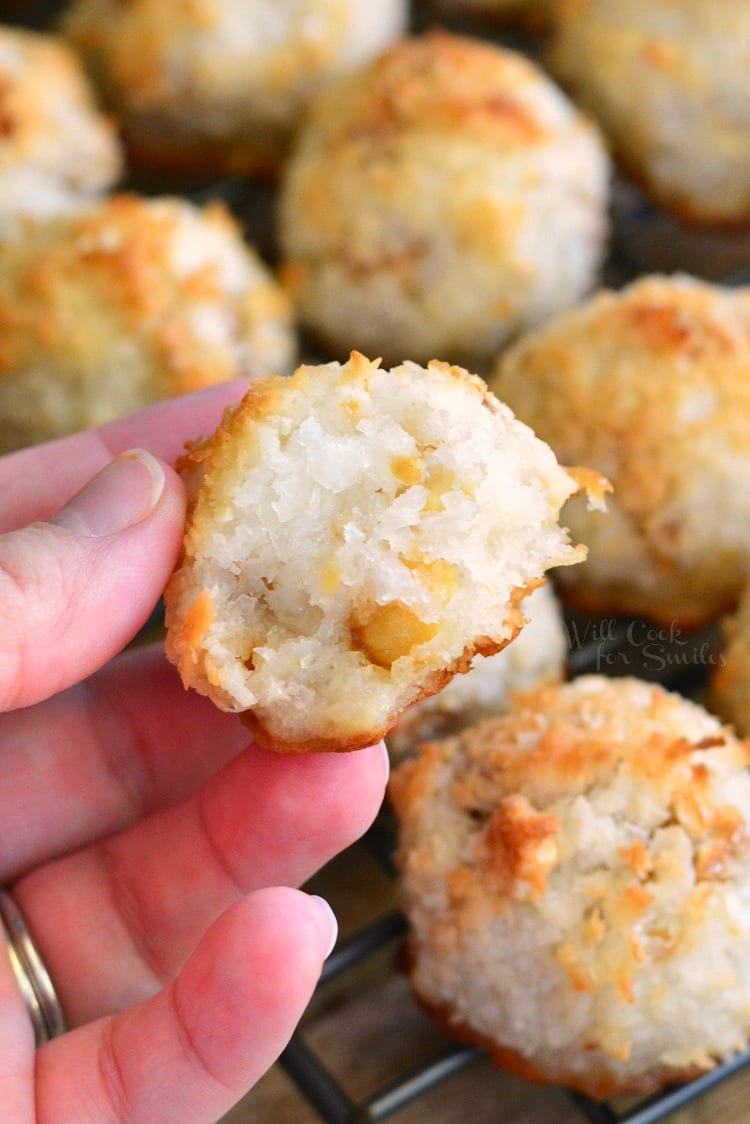 holding a piece of a Salted Cashew Coconut Macaroon in my hand with the rest of the macaroons in the background  