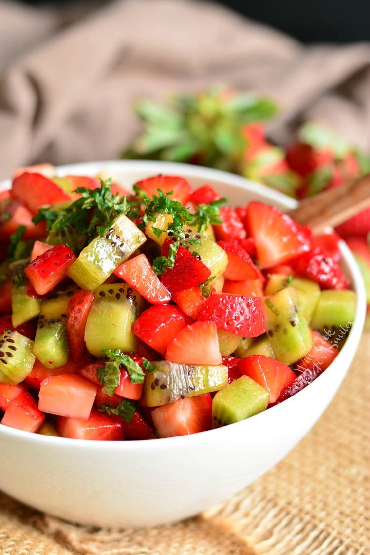 Strawberry Kiwi Fruit Salad in a bowl with a wooden spoon 