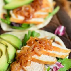 Chicken in a soft taco with lettuce and avocado.