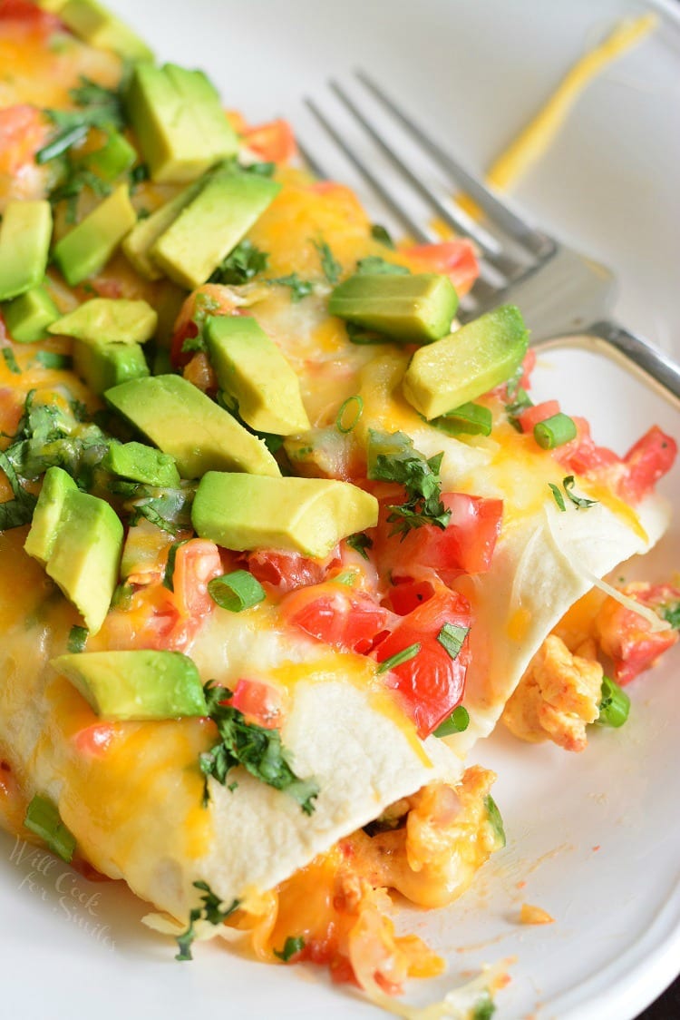 Western Omelet Breakfast Enchiladas on a plate with a fork 