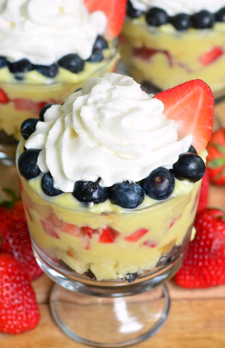 Easy Coconut Berry Trifle in a glass serving bowl on a cutting board with a strawberries 