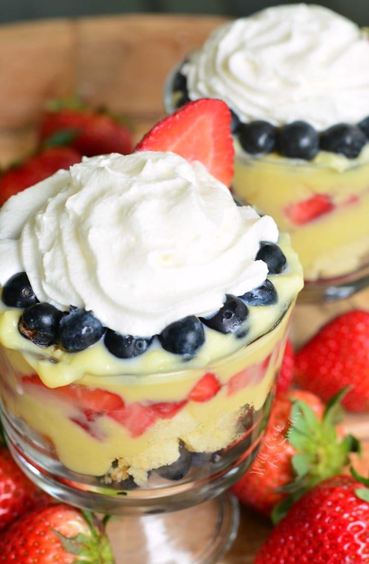 Easy Coconut Berry Trifle in a glass serving bowl on a cutting board with a strawberries 